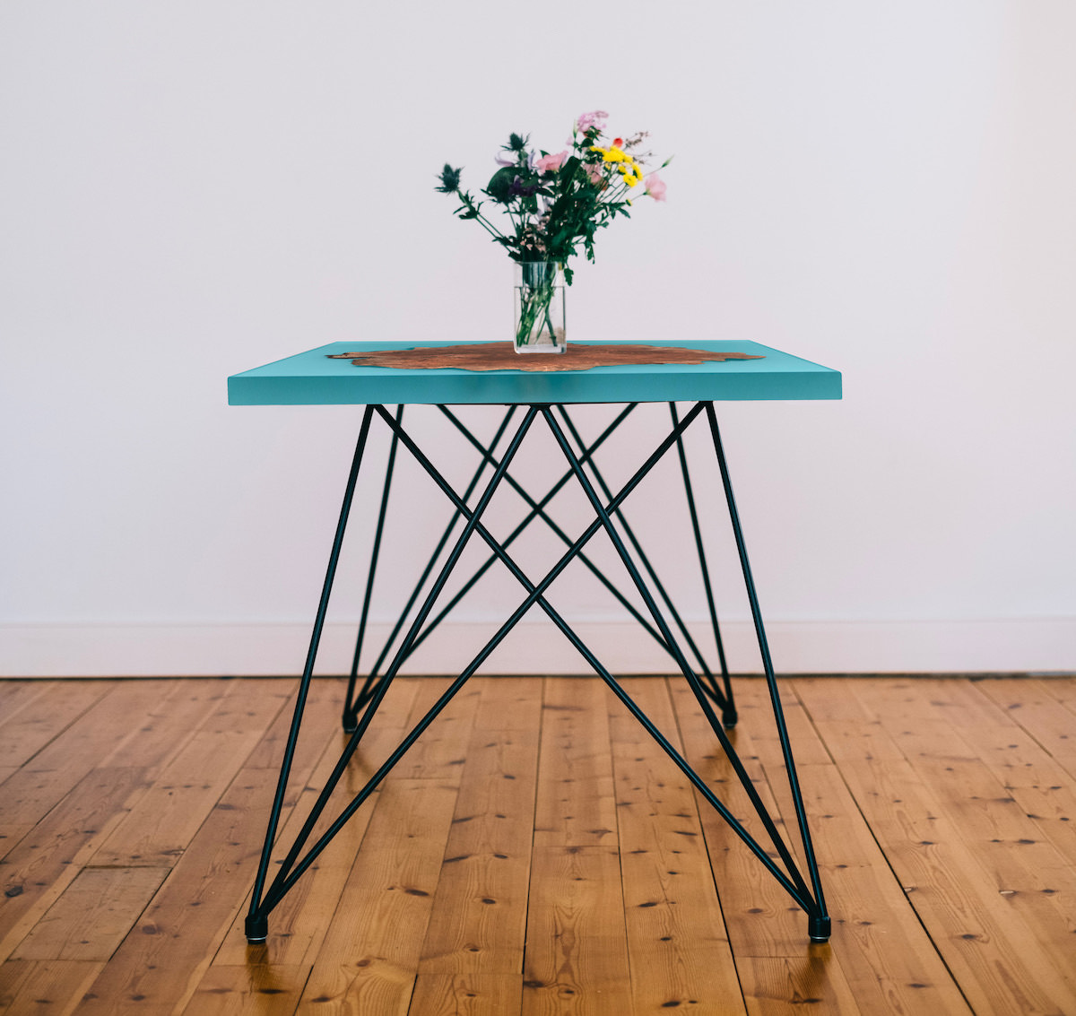 table epoxy de couleur bleu claire sur pieds fin type epingle de cheveux